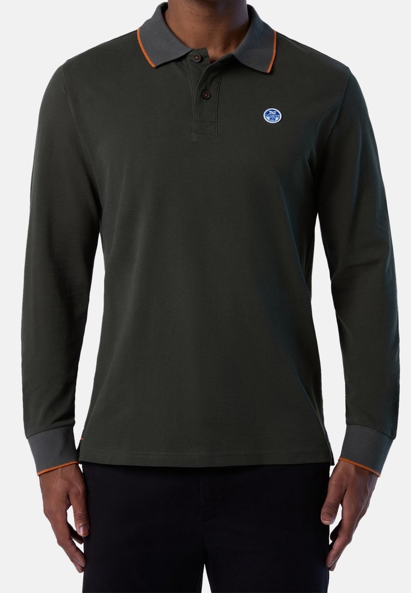 Polo à manches longues en coton vert foncé, avec un col gris aux accents orange et un logo rond sur la poitrine.