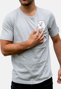 Helles graues T-Shirt mit kurzen Ärmeln, aus weicher Baumwolle, mit einem schwarzen Cartoon-Bären-Design im Bereich der linken Brusttasche.