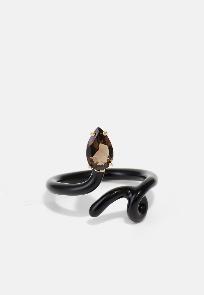 Črn kovinski prstan z zvitim dizajnom, ki ima zlato obrobo in na sredini hruškasto oblikovan rjav kamen.