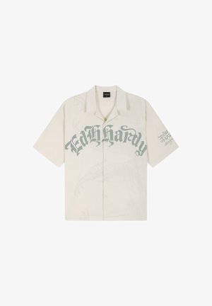 Beiges kurzärmliges Hemd mit Knöpfen und großem gotischem Schriftzug „Ed Hardy“ auf der Brust sowie kleinem Text auf dem rechten Ärmel.