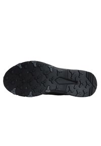 Black athletic shoe sole featuring a textured rubber tread pattern, with various shapes for enhanced grip and durability.