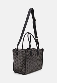 Black and beige rectangular tote bag with repeating "Emporio Armani" logo pattern, dual handles, and adjustable shoulder strap.