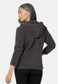 Sweat-shirt capuche gris foncé en tissu texturé, avec une coupe décontractée et des poignets retroussés, présentant des petites speckles subtiles et une poche kangourou.