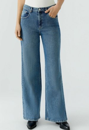 Weite blaue Denim-Jeans mit hoher Taille, ausgestattet mit Fronttaschen und einer glatten Textur. Klassisches Fünf-Taschen-Design mit Reißverschluss.