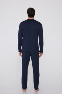 Námořnická modrá halenka s dlouhým rukávem a odpovídající kalhoty vyrobené z měkké tkaniny, těsný design s kulatým výstřihem a rovnými nohavicemi, nošeno naboso.