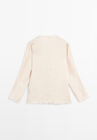 Langärmliges Oberteil aus leicht beige knitterigem Stoff mit rundem Ausschnitt und geradem Schnitt. Minimalistisches Design, keine sichtbaren Beschläge oder Akzente.