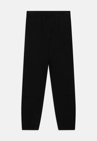 Čierne jogger nohavice vyrobené z jemného materiálu, s elastickým pásom, jednou zadnou vreckom a zužujúcimi sa manžetami. Minimalistický dizajn bez vzorov.