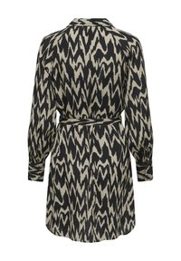 Φόρεμα με μακριά μανίκια σε μαύρο και μπεζ χρώμα με αφηρημένο ζιγκ-ζαγκ σχέδιο, ζωνάκι στη μέση, γιακά και κουμπωτές μανσέτες. Κατασκευασμένο από ελαφρύ ύφασμα.