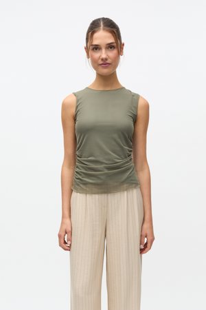 Haut sans manches vert olive avec détails froncés sur les côtés, fabriqué dans un tissu lisse et extensible, associé à un pantalon beige clair à fines rayures.