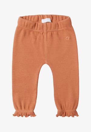 Leggings pour tout-petits en orange côtelé avec une taille élastique et des poignets volantés. Présente un petit logo brodé près de la taille.