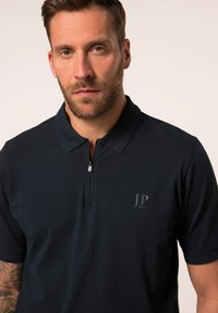 Námořnická polo košile vyrobená z hladkého materiálu, s krkem na zip, krátkými rukávy a decentním logem 'JP 1880' na levé hrudi.