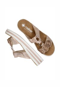 Light pink slide sandals with decorative round embellishments, adjustable strap, cushioned insole, and white striped platform sole.