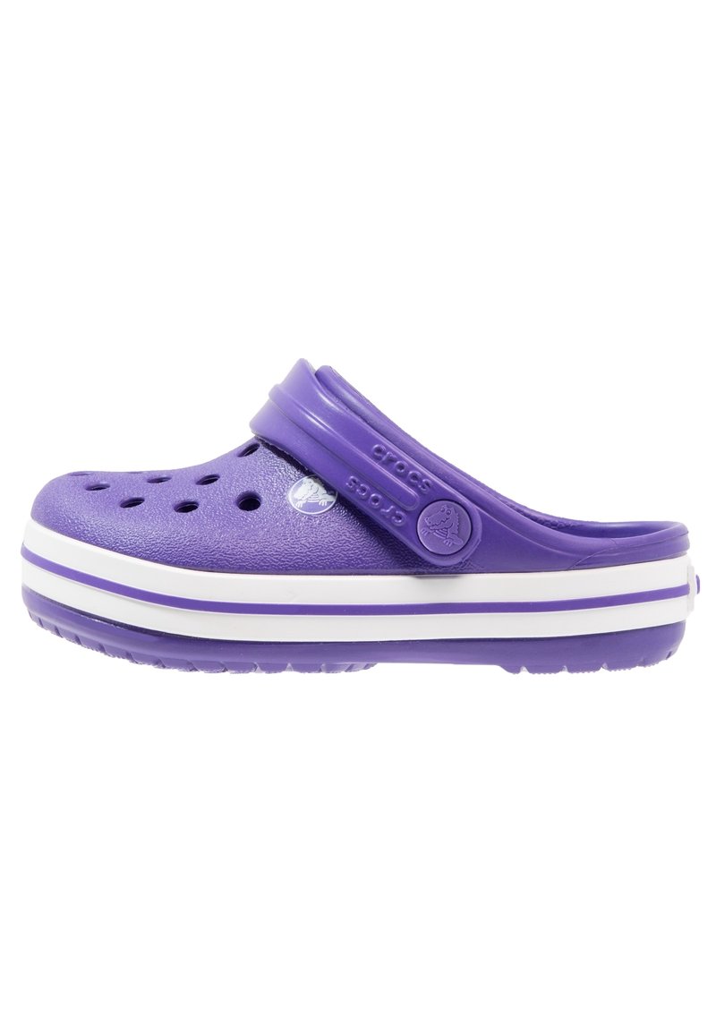 Zoccoli Crocs viola con punta chiusa, fori per la ventilazione, cinturino regolabile e suola a strisce bianche. Realizzati in materiale in schiuma leggero.