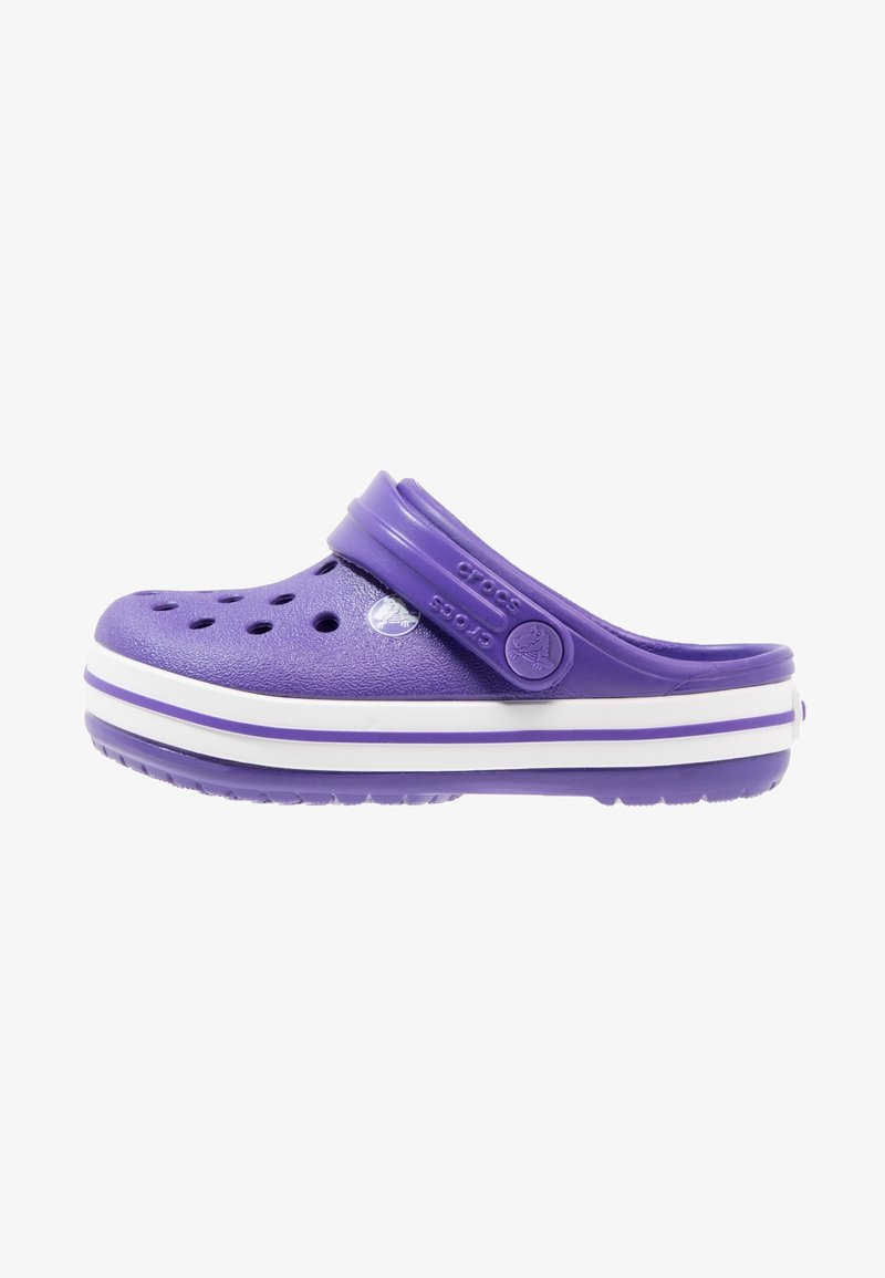 Zoccoli Crocs viola con punta chiusa, fori per la ventilazione, cinturino regolabile e suola a strisce bianche. Realizzati in materiale in schiuma leggero.