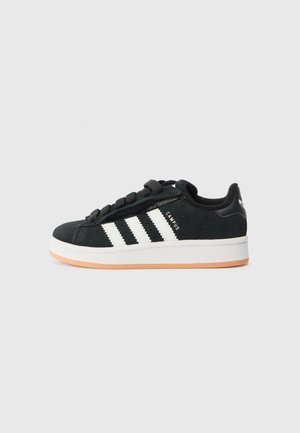 Schwarzer Adidas Campus Sneaker mit weißen Streifen, weißer Sohle, brauner Außensohle und schwarzen Schnürsenkeln, in Seitenansicht auf einfarbigem Hintergrund gezeigt.
