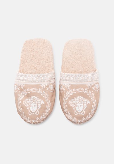 Μπεζ παντόφλες από μαλακό ύφασμα, με υφή στην επάνω πλευρά, περίπλοκο λευκό σχέδιο προσώπου και δάφνης, με διακοσμητικό περίβλημα.