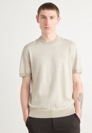 Kurzärmliger, hellbeiger, gestreifter Strickpullover mit geripptem Halsausschnitt und Bündchen sowie einem kleinen Logo-Patch auf der Brust.