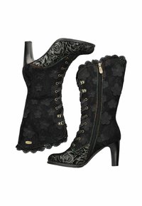 Bottes en dentelle noire avec motifs floraux, talons hauts, bords festonnés et lacets en ruban. Dotées de quincaillerie dorée et d'accents de couture colorés.
