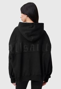 Svart oversize hoodie med huva och texturerad "Allsaint"-tryck på ryggen. Tillverkad av mjukt tyg med avslappnad passform och ribbade muddar.