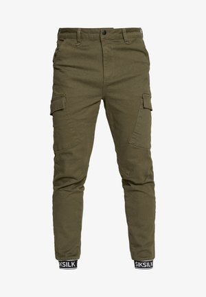Pantaloni cargo in cotone verde oliva, caratterizzati da multiple tasche laterali, gamba affusolata e polsini elastici con banda logata alla caviglia.