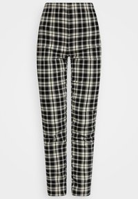 Pantalon à carreaux noir et blanc avec une taille haute, des jambes fuselées et une texture lisse, présentant un motif rectangulaire sur l'ensemble.