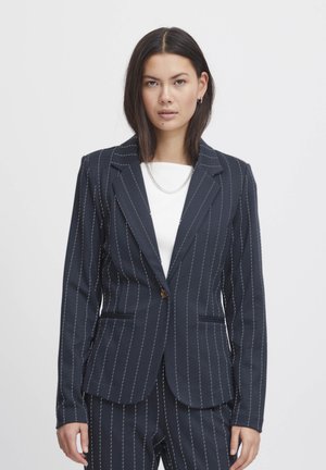 Námořnický blazer s jemným pruhem a klopovými límci, dvěma předními kapsami a zapínáním na jeden knoflík. Tkanina má hladkou texturu a jemný lesk.