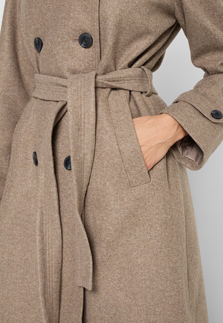 Cappotto marrone in misto lana con doppio petto, bottoni neri, vita con cintura e tasche laterali; texture morbida e vestibilità sagomata.