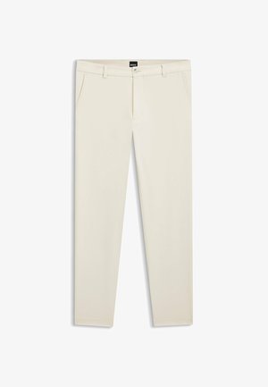 Beżowe, dopasowane spodnie z bocznymi kieszeniami, szlufkami na pasek, zapięciem na guzik i czarną metką na pasku w talii.