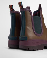 Botas de tornozelo em borracha em castanho e azul-turquesa, com um salto roxo e alças listradas. Sola texturizada com marcação na lateral.