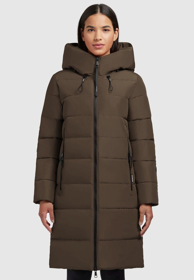 Manteau rembourré marron foncé, doté d'une capuche, d'une fermeture éclair et de poches latérales. Le design matelassé ajoute de la texture et de l'isolation.
