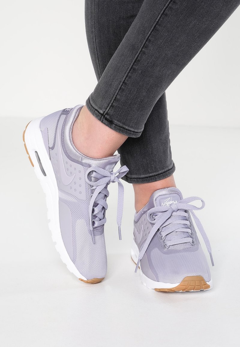 Ljuslila träningsskor i mesh och syntetiska material, rund tå, snörning och en vit sula med akcent i gummirubber.