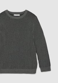 Maglione grigio a costine con colletto rotondo, caratterizzato da un motivo a maglia testurizzato e coste orizzontali e verticali in contrasto. Maniche lunghe e orlo aderente.