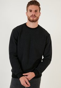 Tumehall soe särk ümmarguse kaelusega ja pika varrukaga. Omab soonikkoes mansette ja räti. Sile tekstuur peene disainiga.