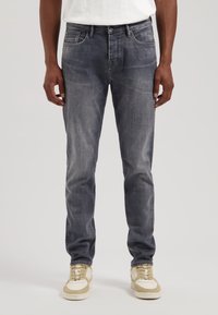 Blugi din denim întunecat cu un aspect uzat, design cu picior drept, cinci buzunare, închidere cu buton metalic și detalii de coasere minime.