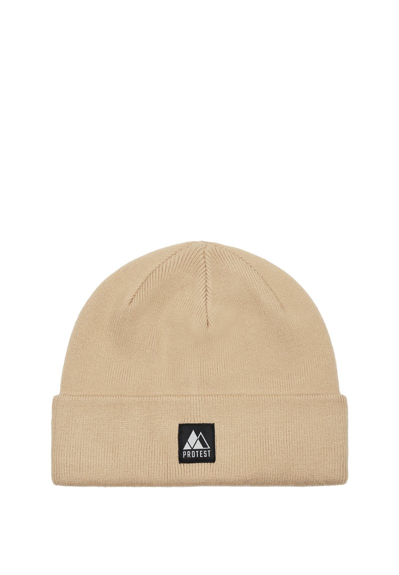 Beige knitted beanie hat with a folded cuff. Features a rectangular black label with a white mountain logo on the front. Soft texture.