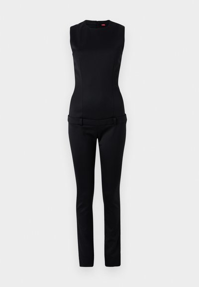Combinaison sans manches noire avec un bustier ajusté et une taille large, présentant des pantalons ajustés et une fermeture éclair à l'arrière. Texture lisse.