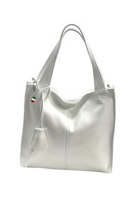 White leather tote bag with a textured finish, featuring two handles, a subtle decorative tag, and a slouchy, lightweight design.