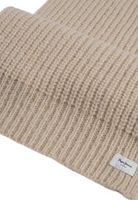 Bufanda de punto beige con textura acanalada. Presenta una pequeña etiqueta de marca en un borde. Material de lana suave, diseñada para proporcionar calidez y comodidad.