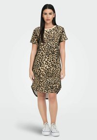 Leopardmönstrad klänning i tan och svart, korta ärmar, rund halsringning och hög-låg fåll. Har en avslappnad passform och mjukt tyg.