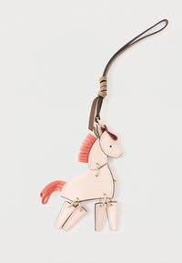 Vaaleanpunainen nahkainen hevosen avaimenperä, jossa on kontrastina oleva punainen mane ja häntä. Varustettu kullansävyisillä yksityiskohdilla ja nivelten liikkuvuudella. 