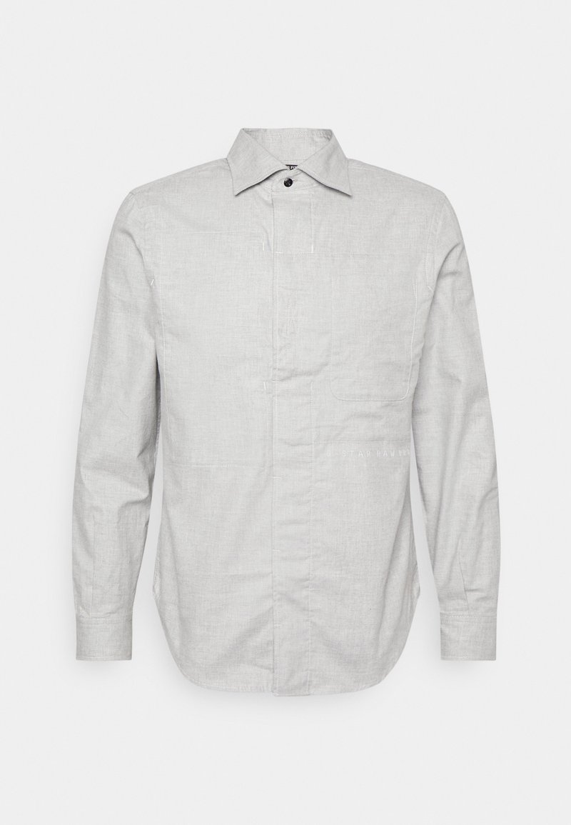 Chemise gris clair à manches longues avec col pointu, patte de boutonnage cachée, poche poitrine et coupe slim.