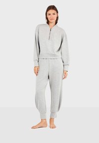 Lichtgrijze sweatshirt en bijpassende joggers van zachte stof. De sweatshirt heeft een half-rits kraag en geribde manchetten.