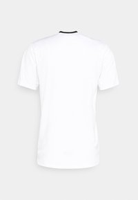 Camiseta blanca de manga corta con cuello redondo, con un acento negro en el cuello, hecha de una tela suave y lisa.