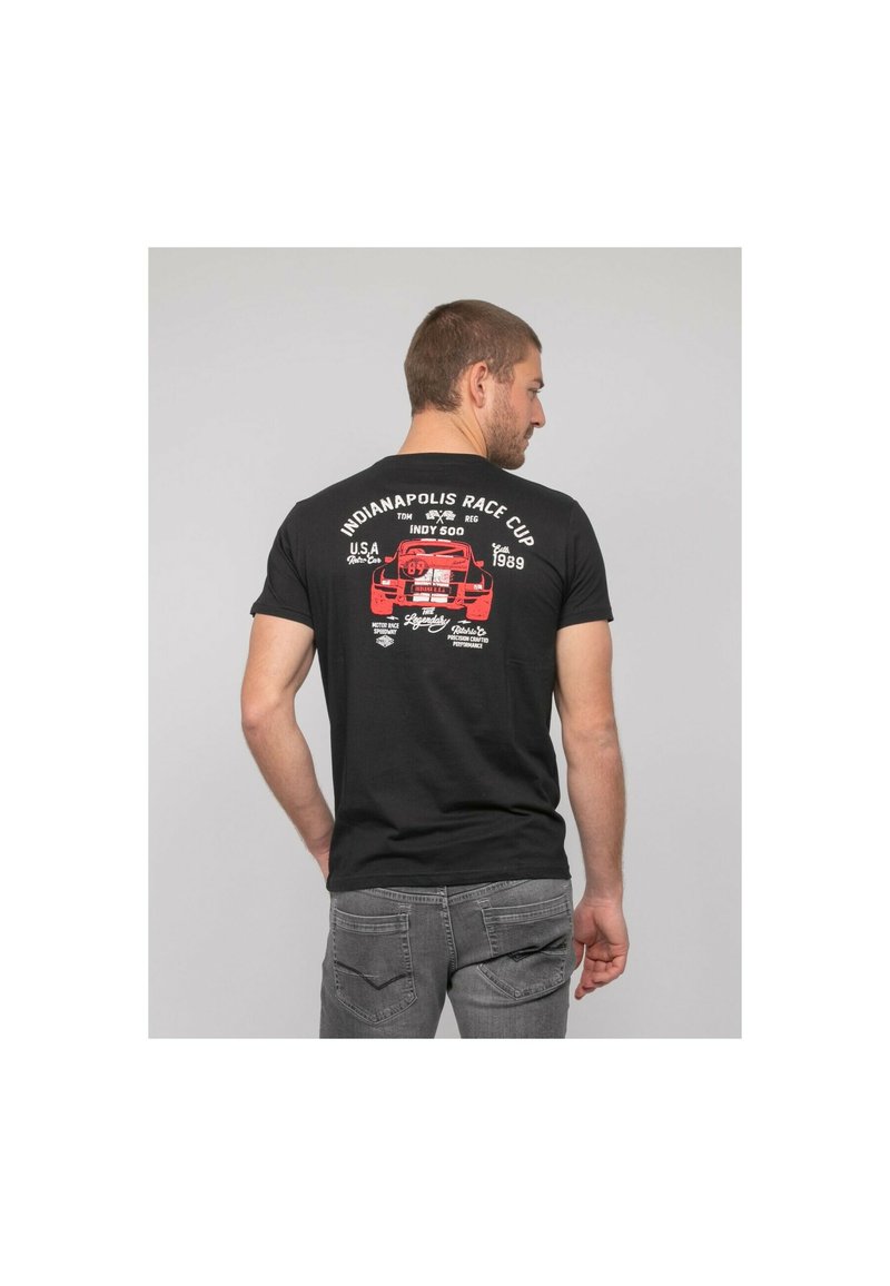 T-shirt en coton noir avec un graphique d'une voiture de course rouge et un texte lié à la Coupe de course d'Indianapolis 1989. Manches courtes, coupe standard.