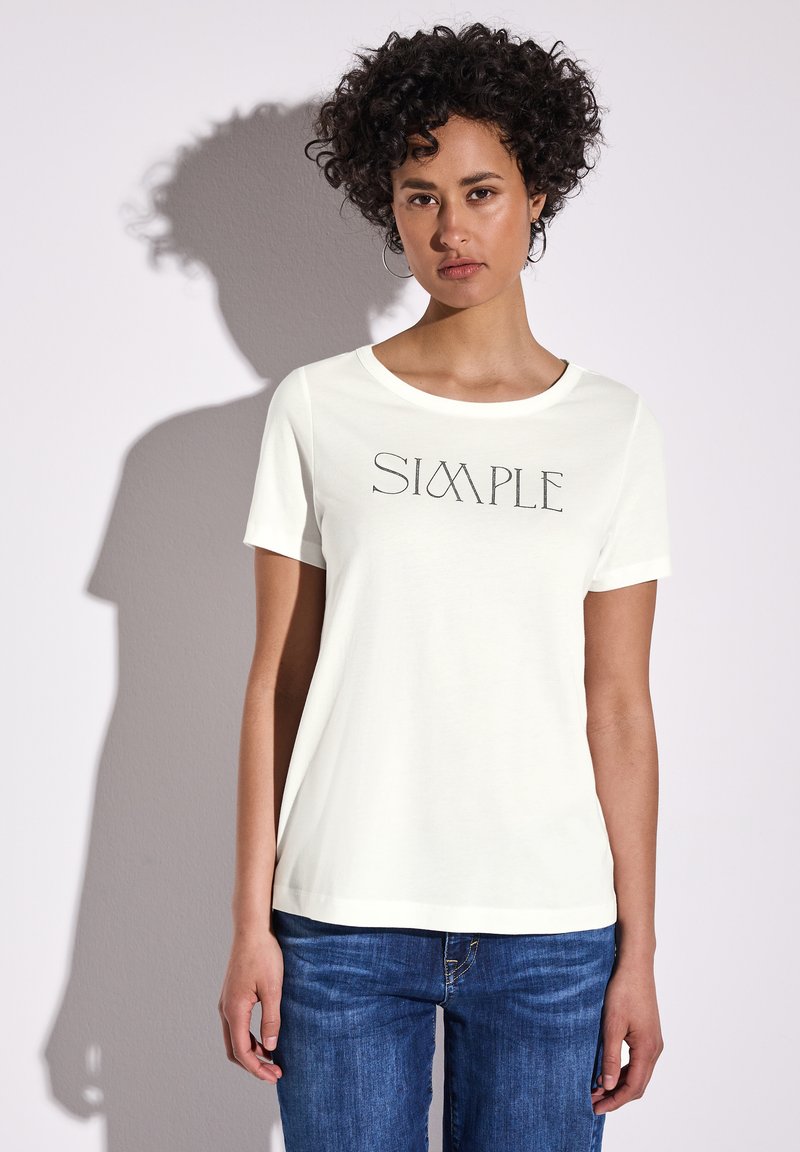 Hvid kortærmet t-shirt med "SIMPLE" trykt i et moderne skrifttype. Har en rund halsudskæring og blødt bomuldsstof. Bæres med blå jeans.