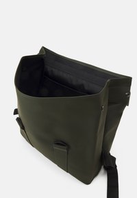 Sac à messager vert avec une finition lisse et mate, de forme rectangulaire, ouverture par le haut, poche intérieure et bandoulière réglable avec accessoires en métal.