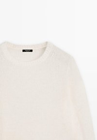 Maglione morbido color crema con collo rotondo, colletto e maniche a coste, realizzato in un materiale testurizzato e soffice. Etichetta visibile all'interno.