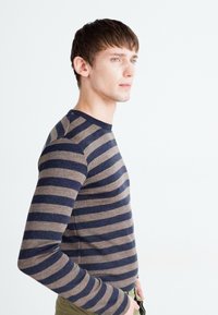 Chemise à manches longues rayée, en marron et bleu marine, en matériau doux, design ajusté, col rond, texture lisse et poignets côtelés.