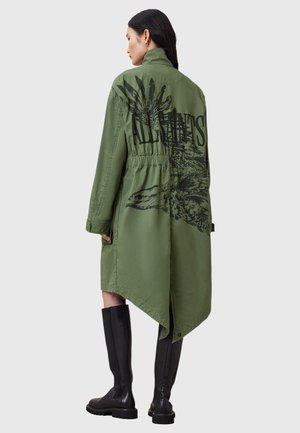 Olijfgroene jas met een trekkoord in de taille, een hoge-lage zoom en een grote zwarte grafische print op de achterkant. Glad materiaal, lange mouwen en kraag.