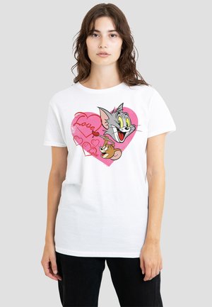 Young woman wearing a white T-shirt with a pink heart, Tom the cat's head, and Jerry the mouse painting "Love" inside the heart.